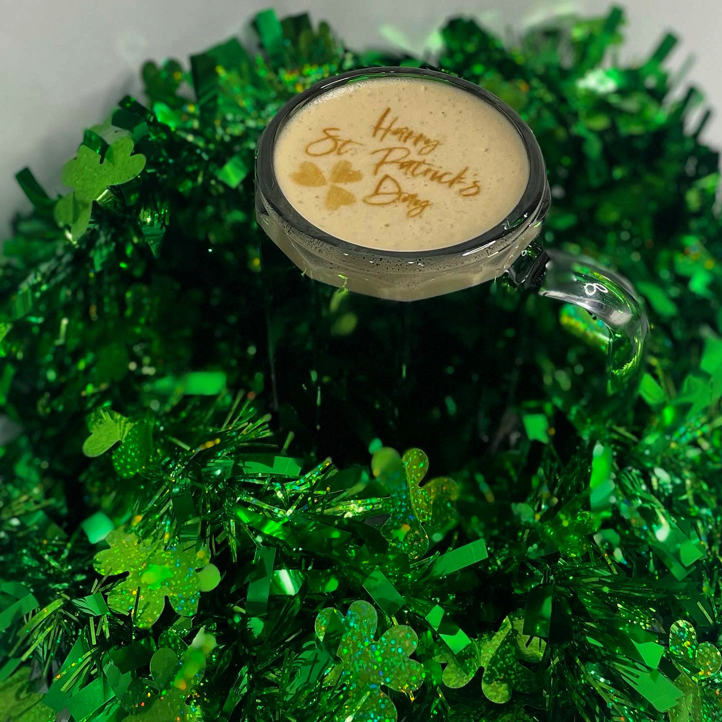 An irish coffee with the words "Happy St. Patrick's Day" on the foam