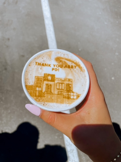a hand holding a coffee cup that says "Thank you Abby PD"