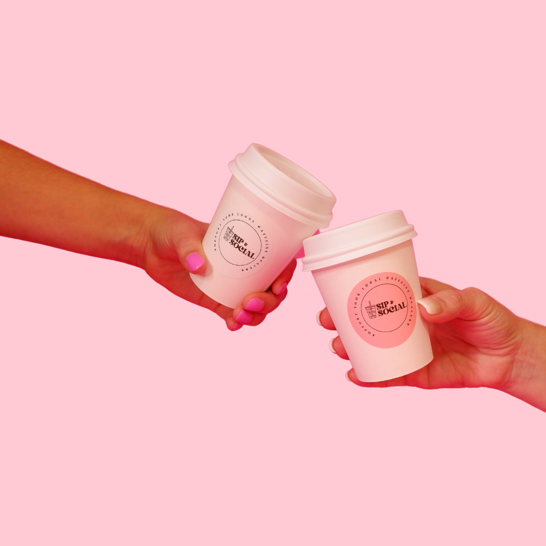 Two hands holding Sip & Social cups